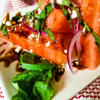 A closeup view of a rectangular shaped plate with Balsamic Watermelon Salad. Cooking With Fudge