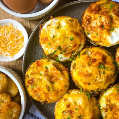 Healthy Egg Muffins With Hash Browns with side dishes of eggs, shredded cheese, cooked onion and bell pepper, and hash browns. Cooking With Fudge